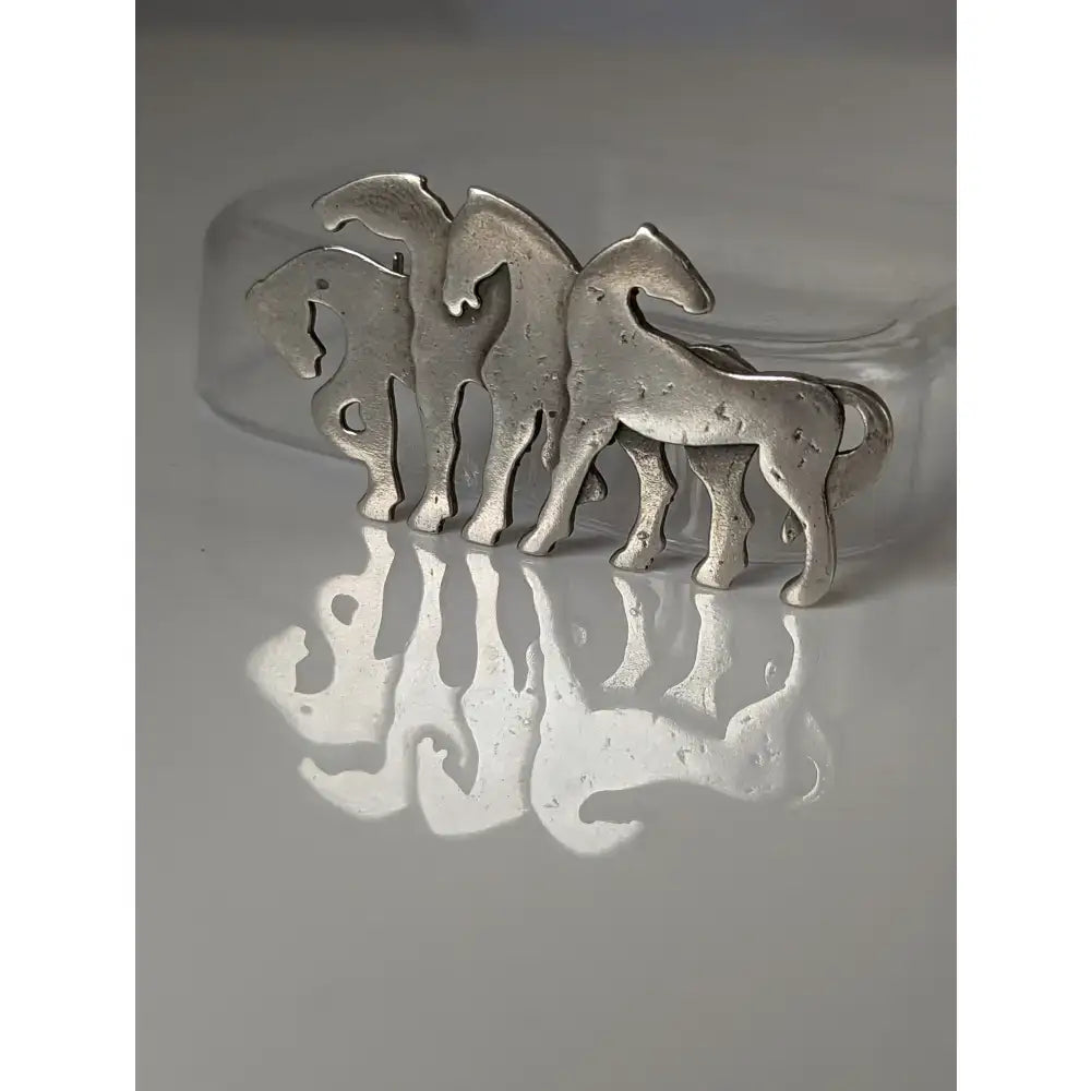 Silver steed signature silver-toned herd silver brooch with three stylized horses for use as a stock tie pin
