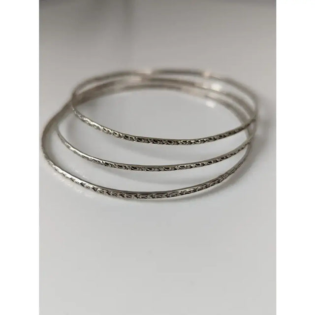 Set of three silver steed slim vine silver bangles with intricate engraved patterns on silver-toned metal