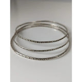 Three silver steed slim silver bangles with intricate vine patterns engraved along outer edges