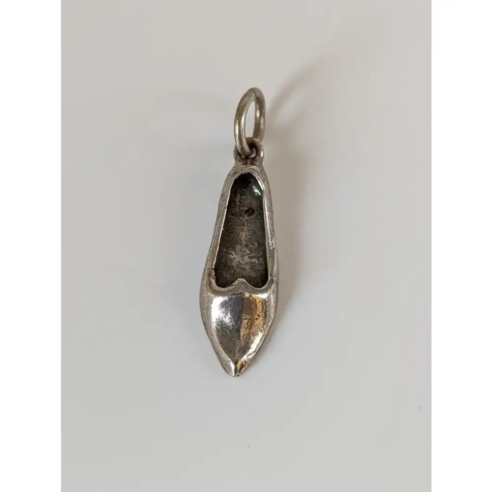 Silver steed slipper silver pendant featuring a silver metal charm shaped like a pointed toe high-heeled shoe with loop
