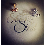 A pair of small silver horse stud earrings in silver and rose gold with detailed metallic craftsmanship