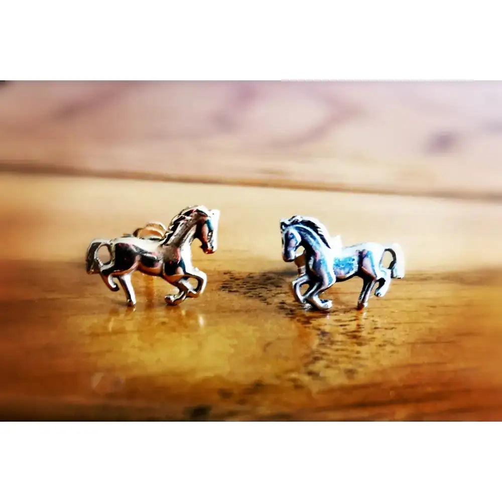 Silver horse stud earrings in small silver sterling design with detailed manes in a dynamic galloping pose