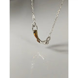 Silver steed snaffle necklace with a silver and gold-toned horsebit pendant and polished two-tone finish