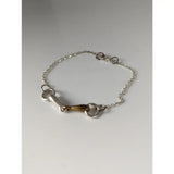 Silver steed snaffle chain delicate bracelet featuring a silver horsebit with a brass center and linked chain design