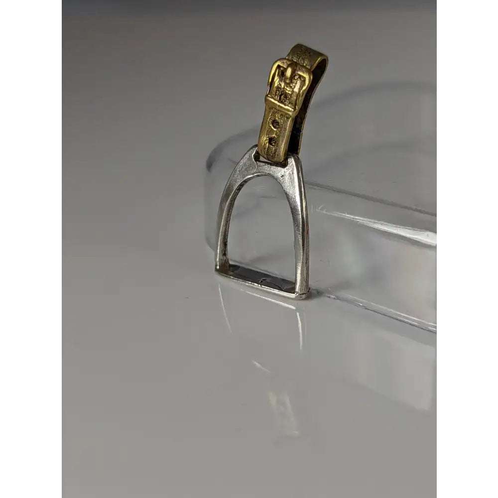 Silver steed stirrup silver pendant with a silver horse stirrup and a gold-colored buckle detail