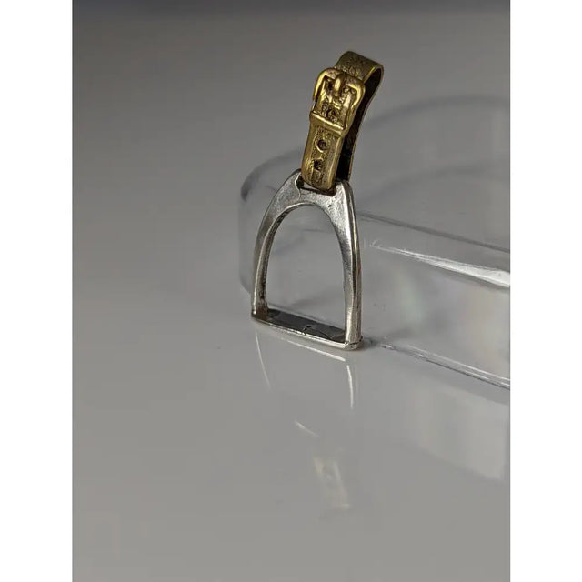 Silver steed stirrup silver pendant with a silver horse stirrup and a gold-colored buckle detail