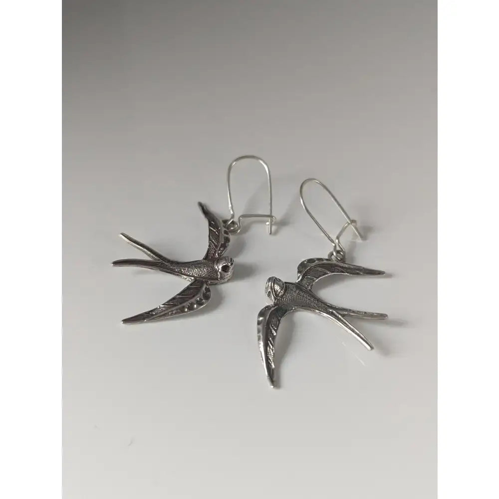 Silver steed swallow silver dropped earrings featuring detailed wing and body textures in sterling silver