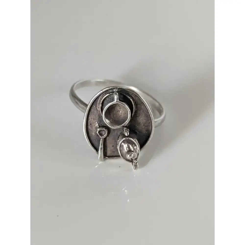 Silver steed tea ring with silver craftsmanship features a circular abstract face with three interconnected cups and dangles