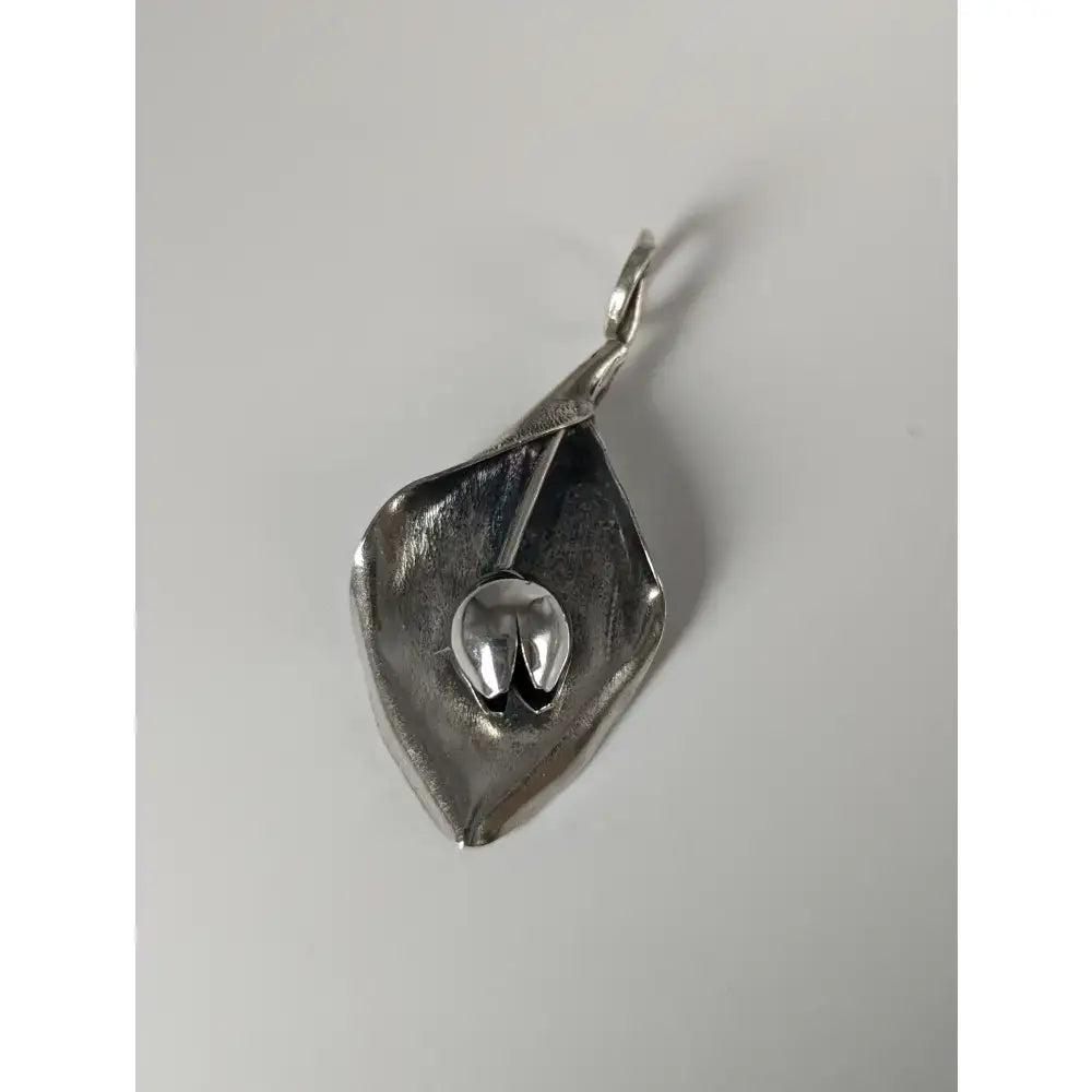 Silver steed tulip pendant featuring a polished silver calla lily petal with a detailed central seed pod