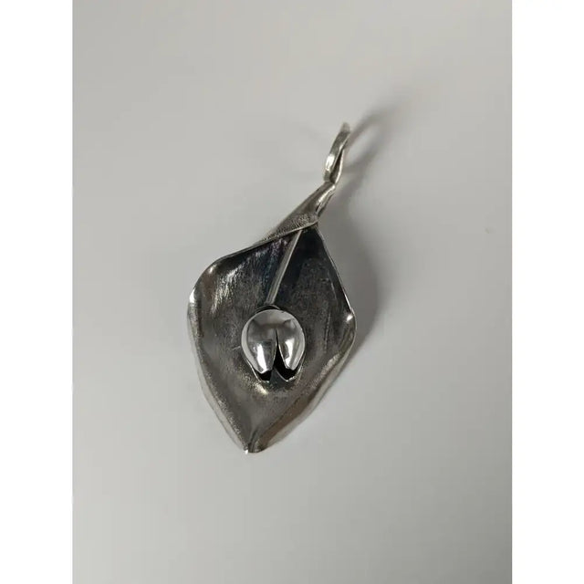 Silver steed tulip pendant featuring a polished silver calla lily petal with a detailed central seed pod