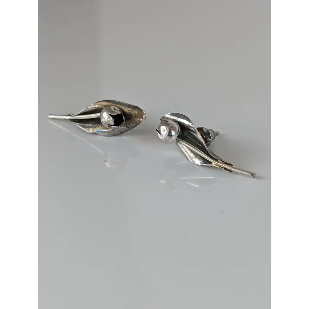 Silver steed tulip stud earrings with silver leaf shape, polished finish, subtle texture, and central spherical accent