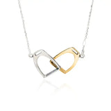 A delicate silver steed two stirrups necklace with interlocking silver and gold horsebit pendants on a fine chain
