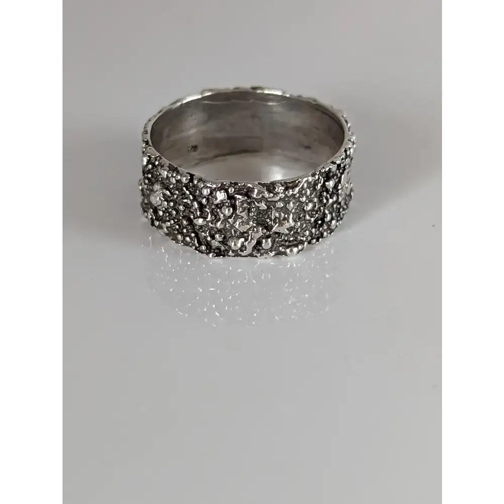 A silver steed unique structure ring crafted from silver with a textured rough bumpy surface like mineral formations