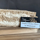 A simply sandwiches sandwich with wholemeal bread and chicken mayo on a wooden board without sugar coatings