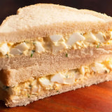 A classic simply sandwiches egg salad sandwich with creamy yellow filling and diced eggs on white bread for a quick snack