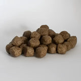 Brown round kibble pellets of skinner’s field & trial salmon rice dog food with salmon & rice ingredients