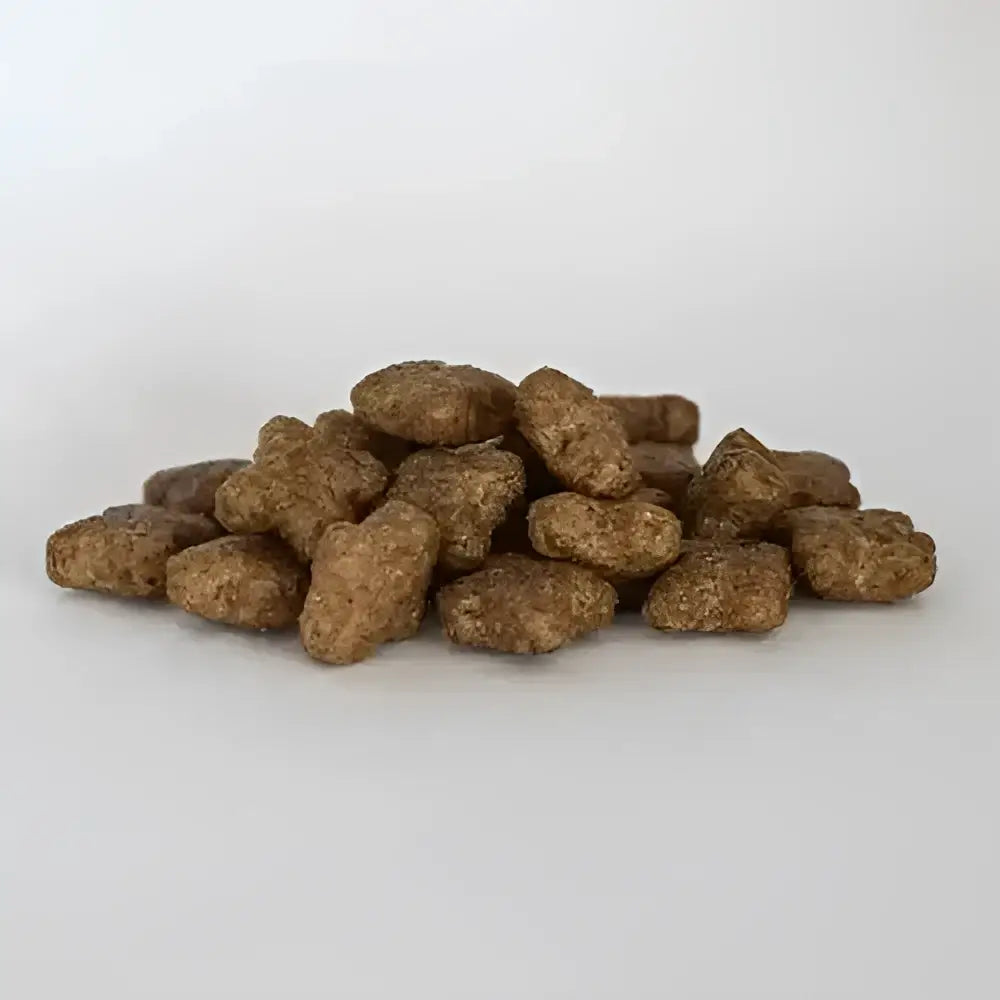 Brown textured kibble pellets for skinners maintenance plus working dry dog food for field and trial use piled together
