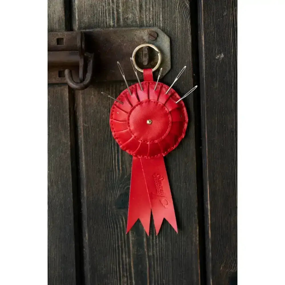 Red leather smart grooming rosette pincushion keyring with circular design and silver needles for easy use