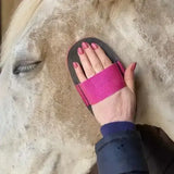 A vibrant pink and black super groomer deluxe brush with a wide padded strap for smart grooming and removing dried caked mud