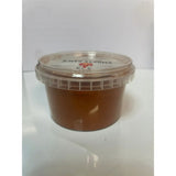 A clear plastic container of smokey sam’s smoked paprika with a brownish orange smoked paprika spread inside