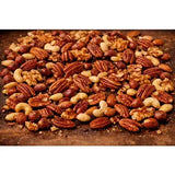 A generous pile of smoky sam’s honey roast hickory smoked nuts with pecans cashews walnuts and hazelnuts on wood