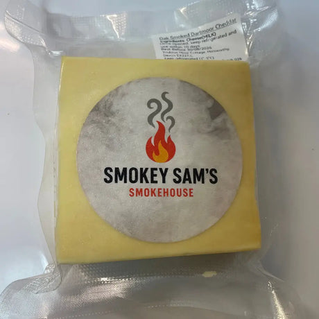 A square block of yellow oak smoked dartmoor cheddar from smokey sams oak wrapped in clear plastic with flame label