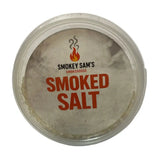Clear plastic container of smokey sams smoked salt with white label bold orange text and flame logo premium sea salt