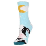 Light blue fuzzy sockshop wild feet cosy adults socks with black and white cow design and yellow crescent moon cuff