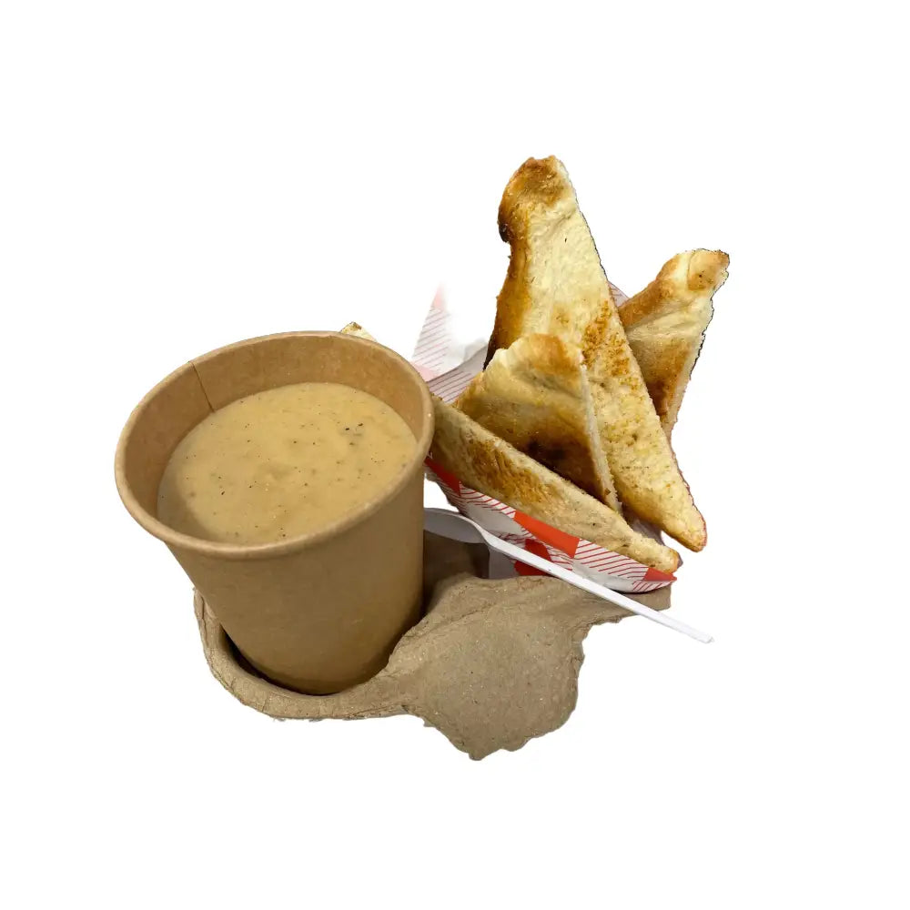 A brown paper cup with creamy soup and crisped up toasted bread perfect for equestrian riders on the go