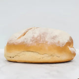 Golden brown sourdough white bread loaf with a scored surface and flour dusting perfect for artisan baking