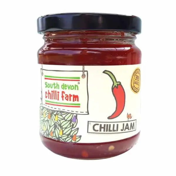A glass jar of south devon chilli farm original chilli jam with a black lid and a white label with red chilli illustrations