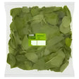 A clear plastic container of fresh green spinach leaves with a bright lime green label ideal for healthy equestrian meals