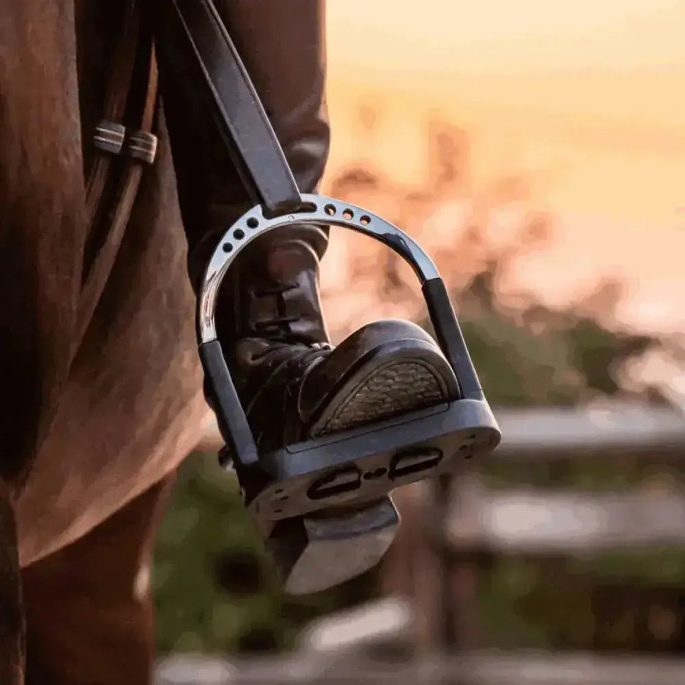 Black sprenger flexicite stirrup with silver metal frame and rubber footbed showing jointed stirrup design