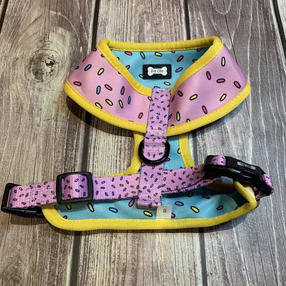 Pink and teal sprinkle print reversible dog harness with yellow trim and black plastic hardware from sprinkles for days reversible size guide