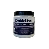 Stableline tea tree antiseptic cream in a white jar with black lid and label for soothing skin care use