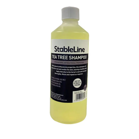 A clear plastic bottle with white cap holds pale yellow stableline tea tree shampoo with natural antibacterial properties for horse coats