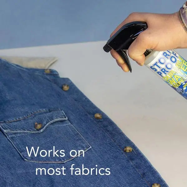 A blue stormproof water repellent spray 500ml with black nozzle being used on denim without nauseating chemical smell