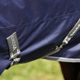 Navy blue StormX Empra Combi Turnout Rug with metal frame and brand tag