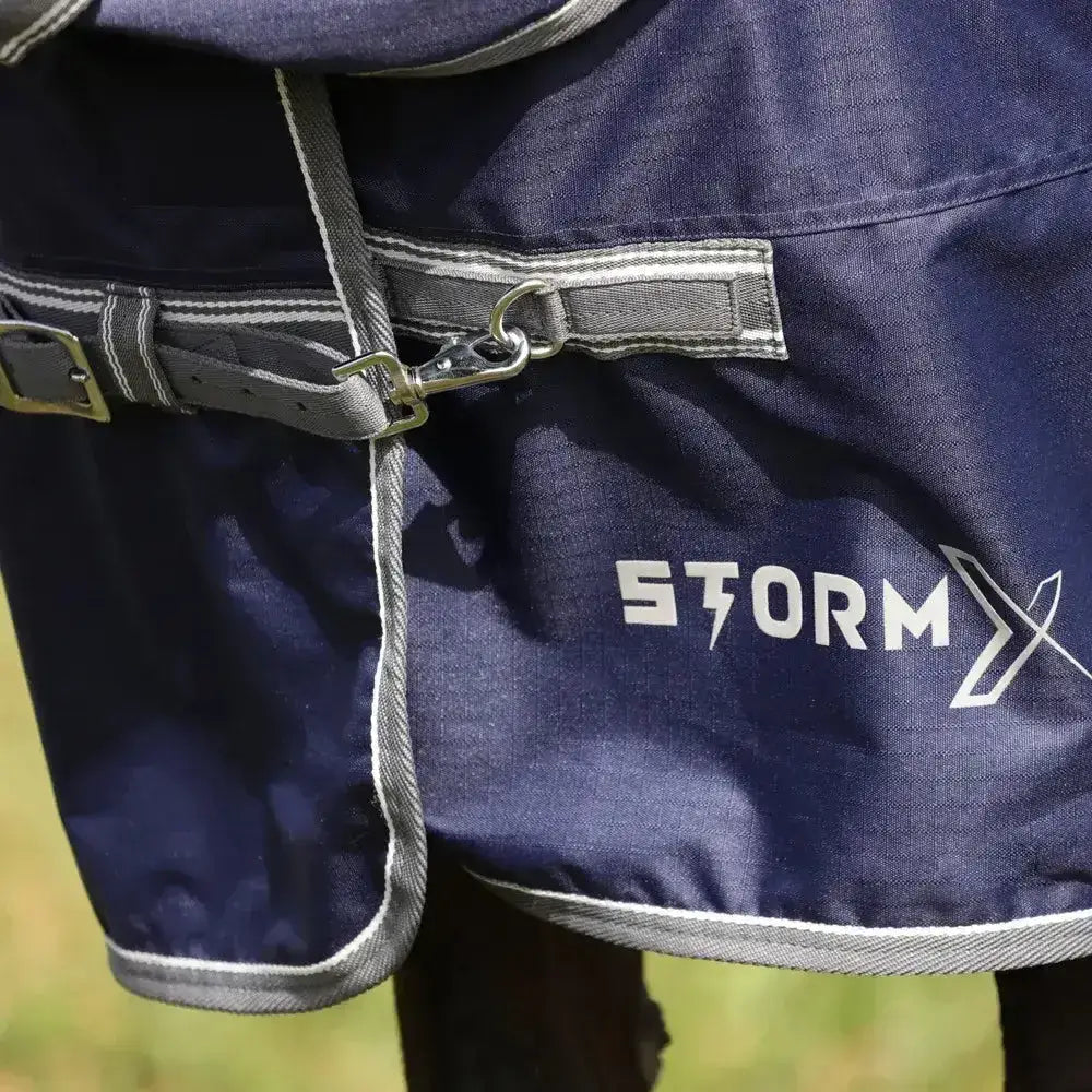 Dark blue stormx empra 100 combi turnout rug with gray trim and silver buckle perfect for horses outdoors