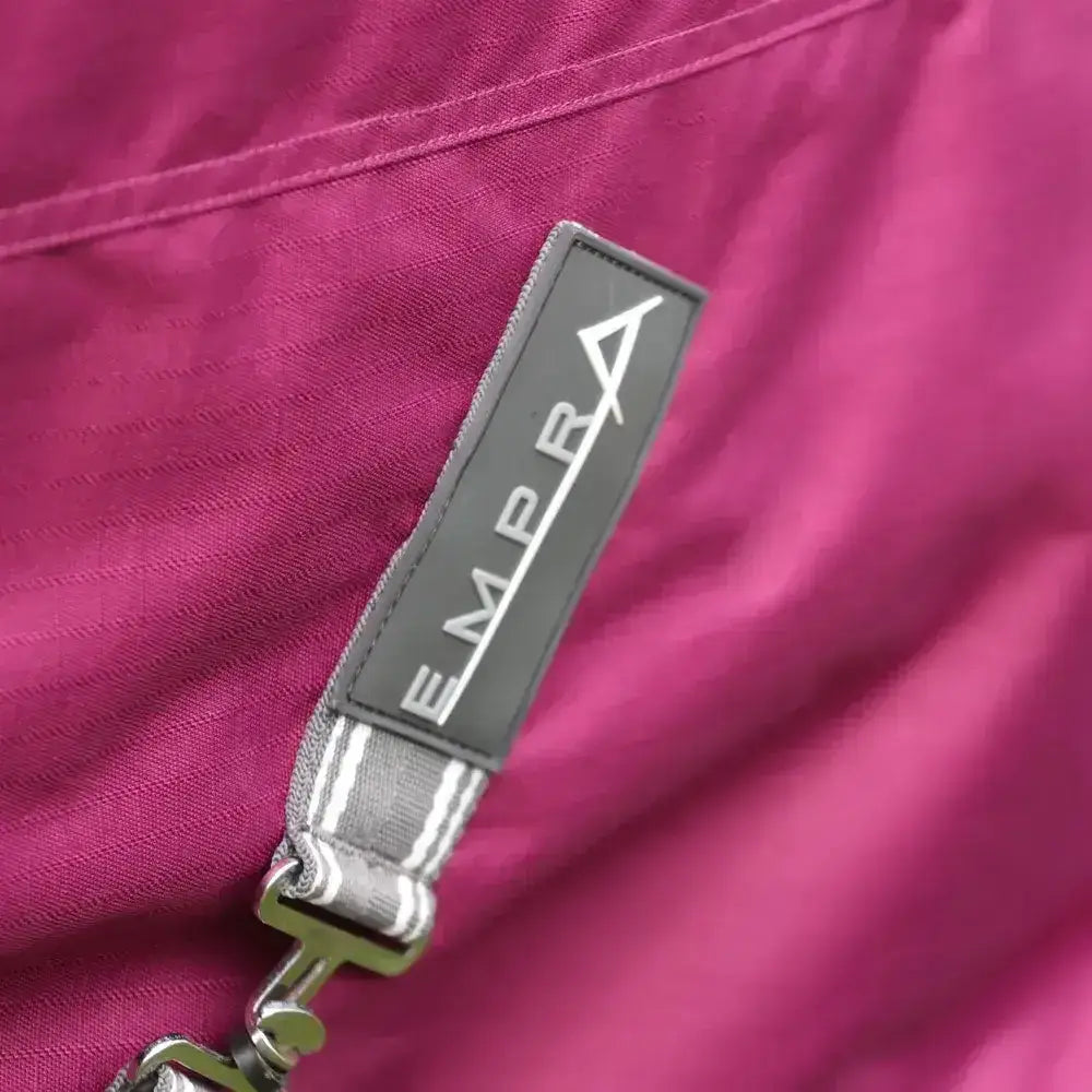 A dark gray stormx empra label on a vibrant magenta combi turnout rug showing the brand name empra