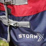 Navy blue and red stormx empra 200 turnout rug with detachable neck gray straps and silver hardware featuring white logo