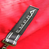 Black rectangular patch with silver empr logo and triangle on gray white strap of stormx empra combi turnout rug