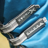 Gray and white striped webbing straps with black patches showing stormx and embra logos on stormx empra combi turnout rug