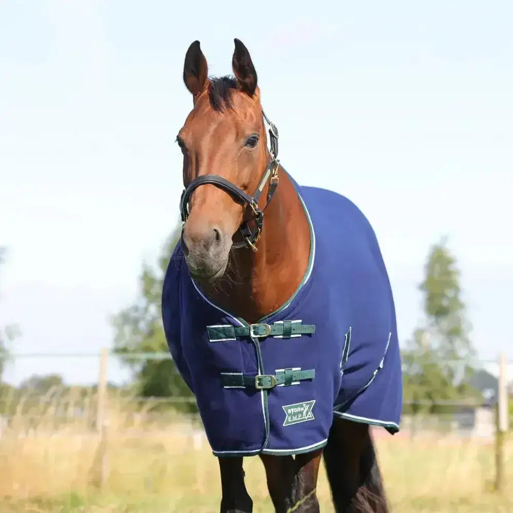 Navy blue stormx empra opulence fleece rug with green buckles white trim and storm rides logo on front