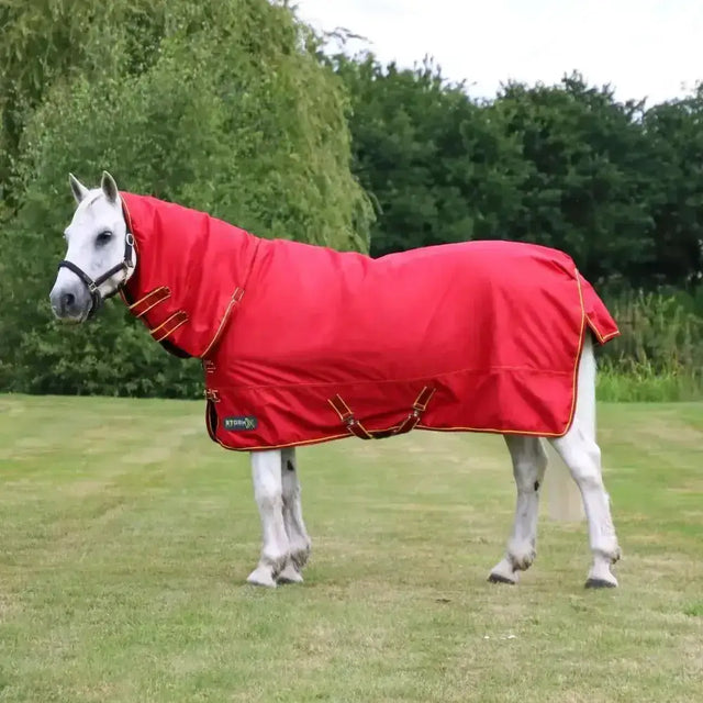Bright red stormx original 200g mediumweight combi turnout rug with gold trim and straps for warmth and protection