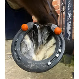 Black horse hoof boot with orange plastic horse studs attached on the sides from studfast box prioritise safety