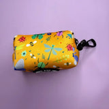 A mustard yellow summer buzzin poo bag holder with colorful bug pattern and black metal clasp for dog walks