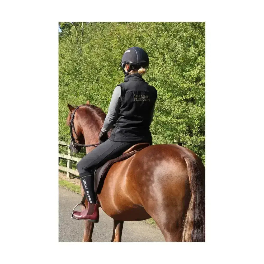 Black supreme products active rider gilet with white lettering and matching black lightweight riding boots