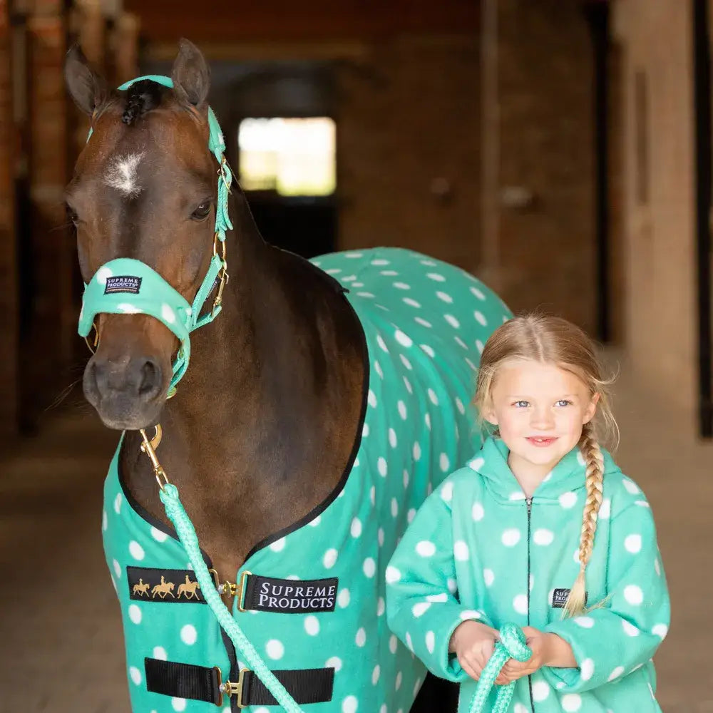 Teal polka-dot horse blanket with black trim and gold hardware made from versatile soft fleece by supreme products dotty fleece rug
