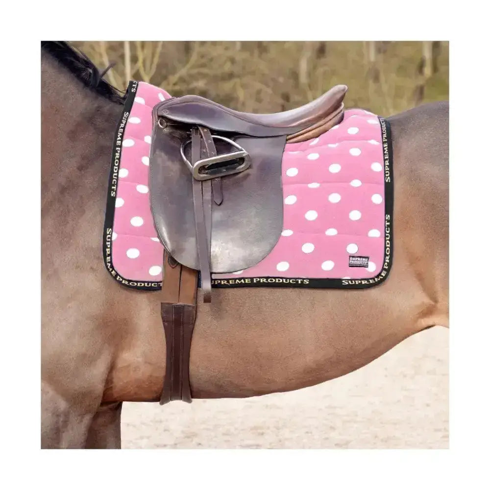 Pink polka-dotted fleece saddle pad with black trim from supreme products dotty fleece saddle for equestrian use